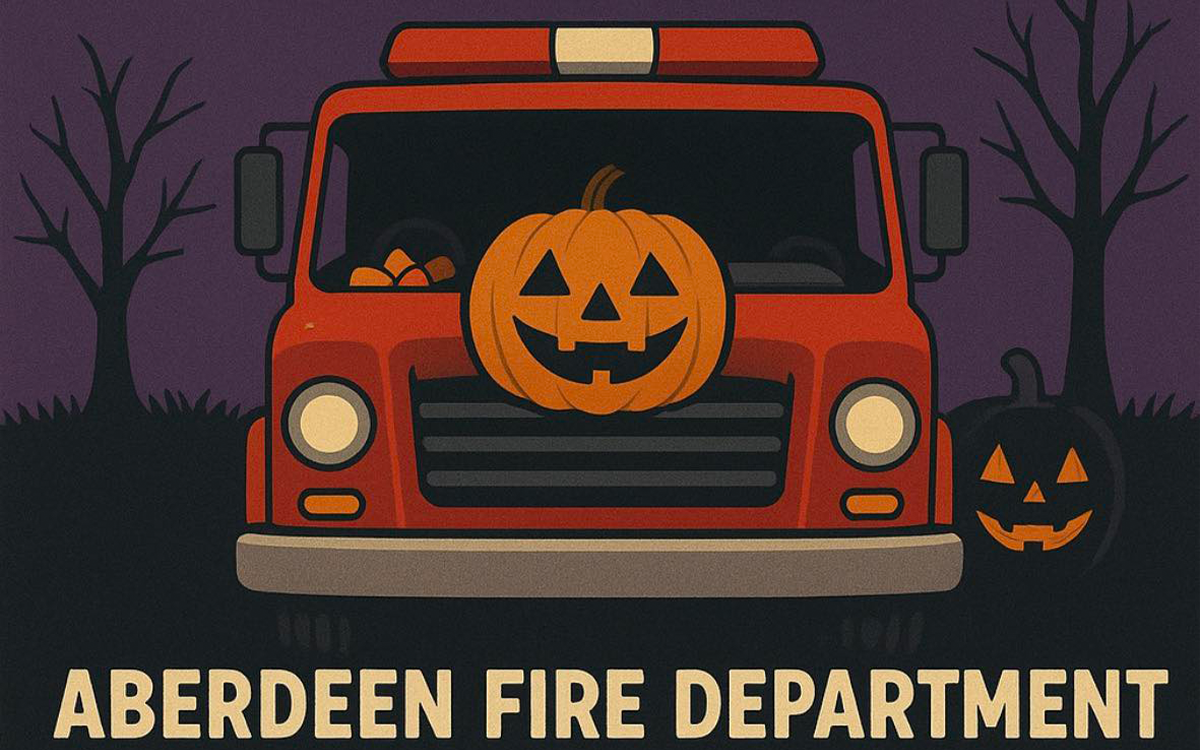A fire truck with jack-o’-lanterns on its grill and beside it. Trees without leaves are in the background. Text below reads “Aberdeen Fire Department.”.